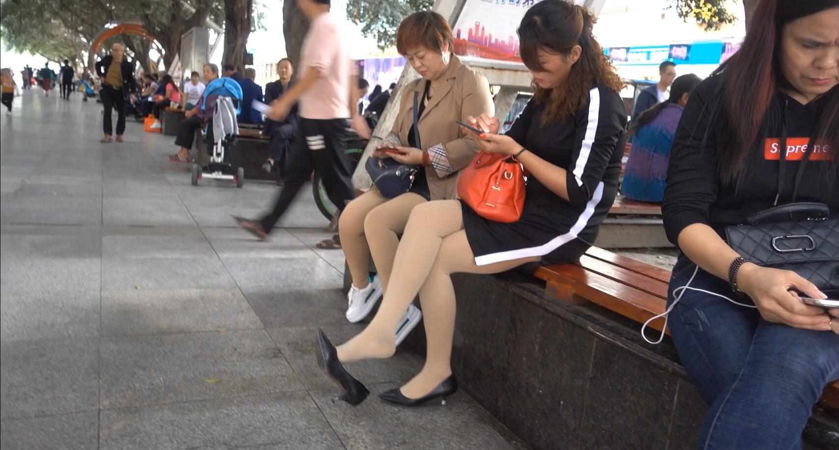 Lady dangling when play cell phone in the park 