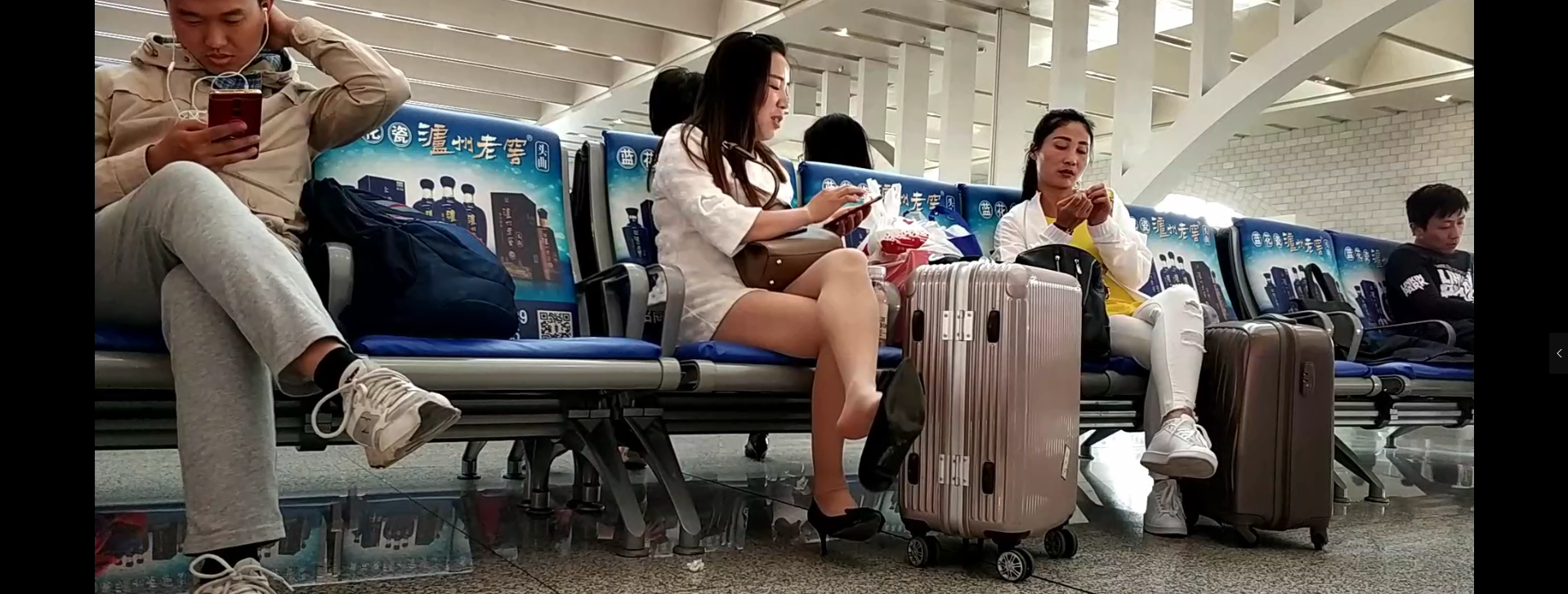 Lady great dangling shoeplay when waiting for the train in railway station lounge 2